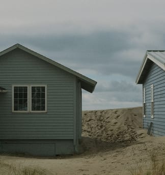 Weathered grey beach cottages on the sand at Pacific City.